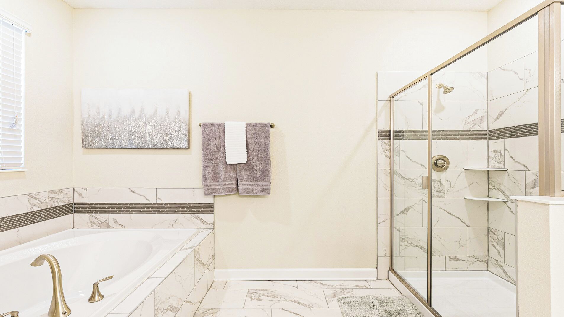 Ein Badezimmer mit Badewanne, Dusche mit Glastüren und Fliesenboden.