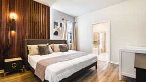 A modern bedroom with a large bed, bedside tables, a wardrobe, and a shower area. - Spacious Home Near Disney With Resort Amenities (Davenport)