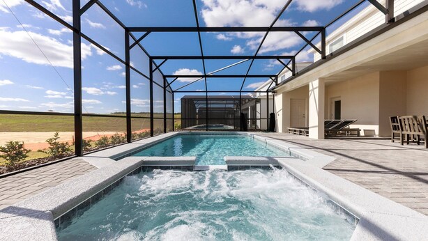 A swimming pool with a view of the countryside, surrounded by a covered patio area. - Windsor Island Let's Make Sunny Memories 2316 (Davenport)