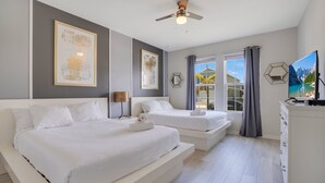 A modern hotel room with two beds, a ceiling fan, a large window with curtains, and a flat-screen TV. - Windsor Island Let's Make Sunny Memories 2316 (Davenport)