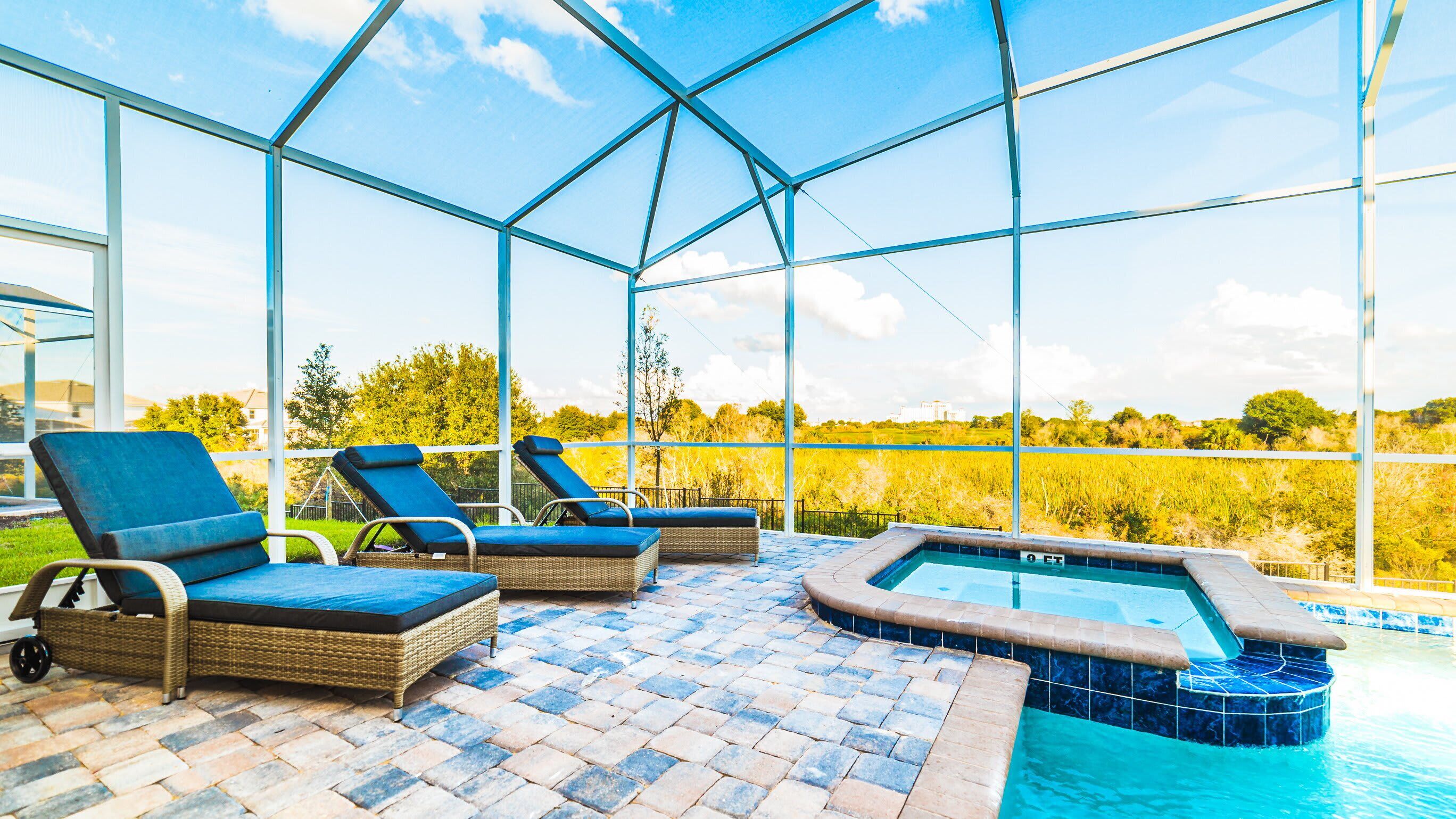 Zona de piscina con sillones de descanso y jacuzzi.