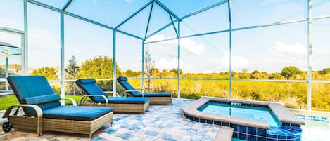 Zona de piscina con sillones de descanso y jacuzzi.