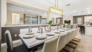 A modern kitchen with a dining area. - Resort-style Home With Pool, Near Disney! (Kissimmee)