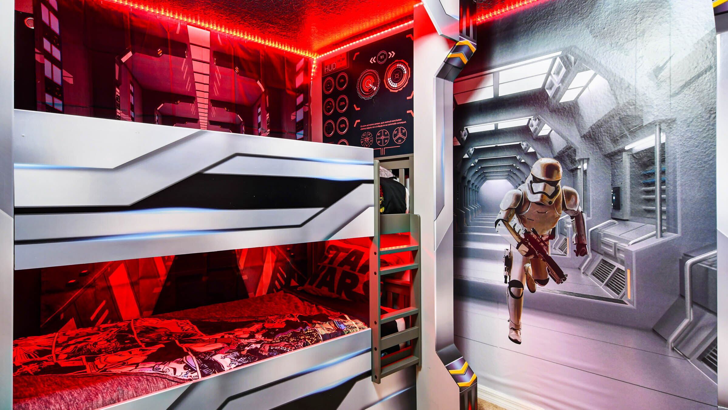Ein Star Wars-zimmer mit Stockbetten, einer Steuerungskonsole und einem Gang mit einer Stormtrooper-Figur.