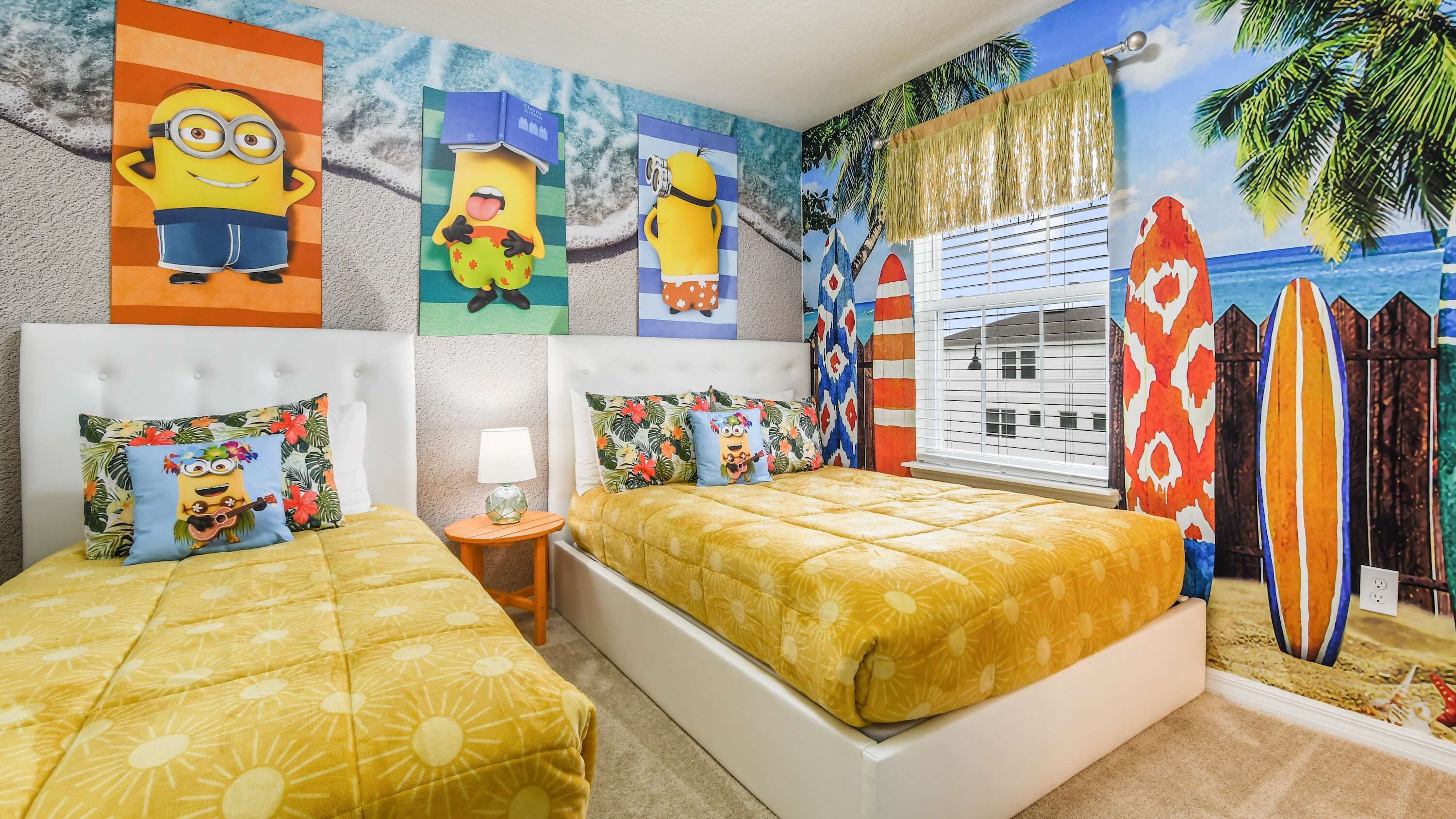 Ein Schlafzimmer mit zwei Betten, einem großen Fenster mit Blick auf einen Strand und Wänden, die mit Minion-Motiven dekoriert sind.