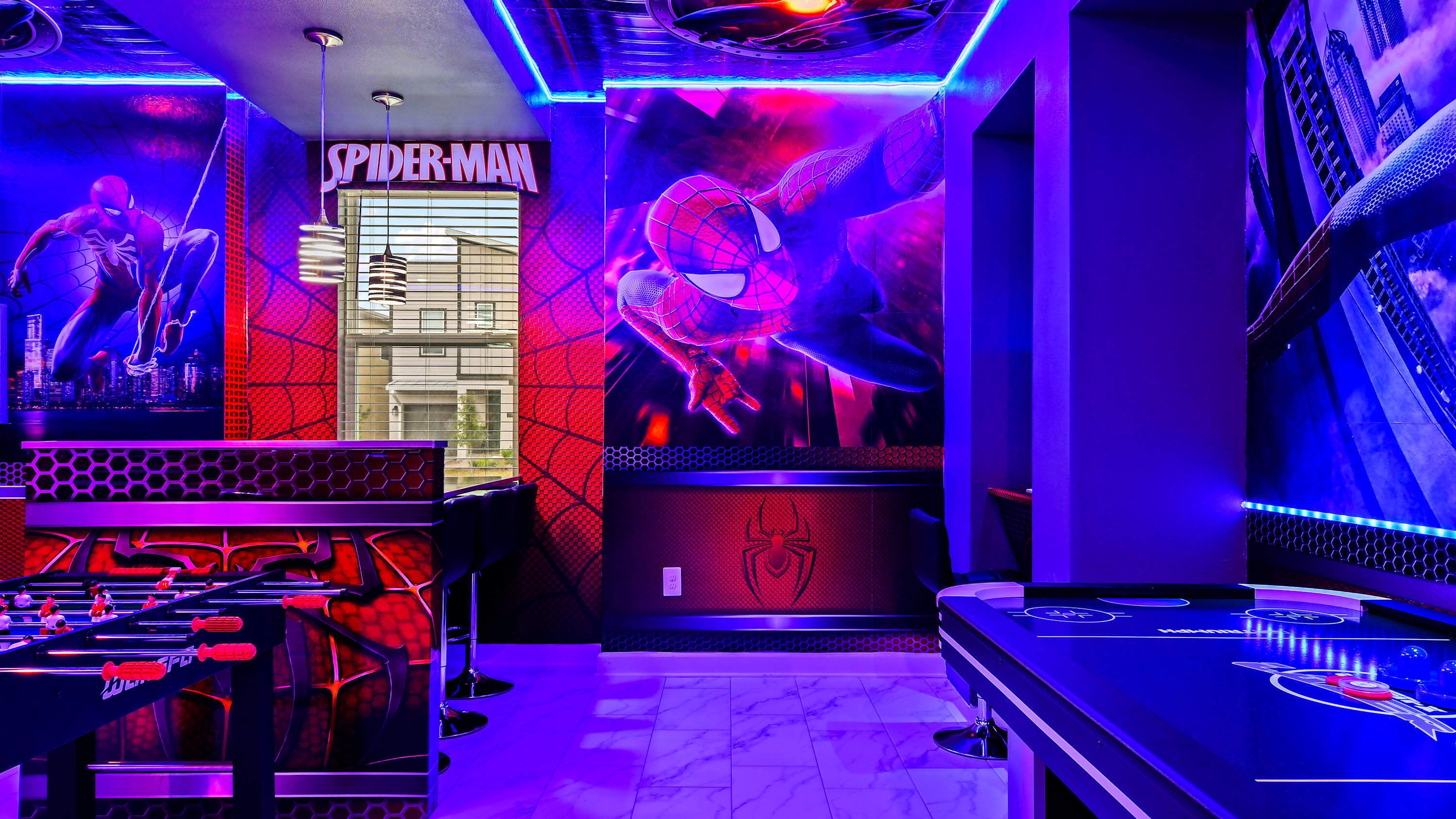 Une chambre décorée sur le thème de Spider-Man, avec des œuvres d’art mural et un panneau à l’effigie de Spider-Man.