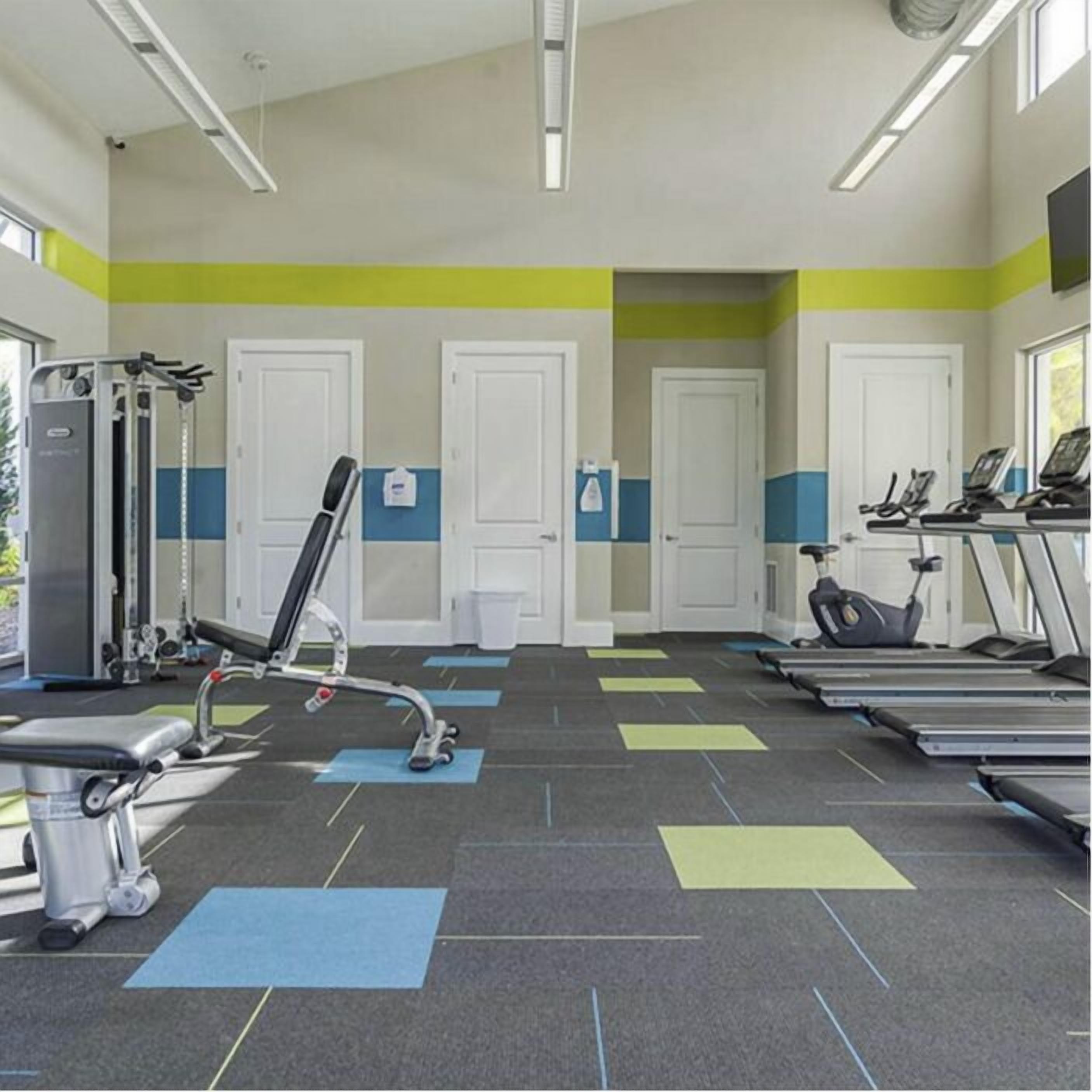 A gym with treadmills, exercise bikes, and weight machines.