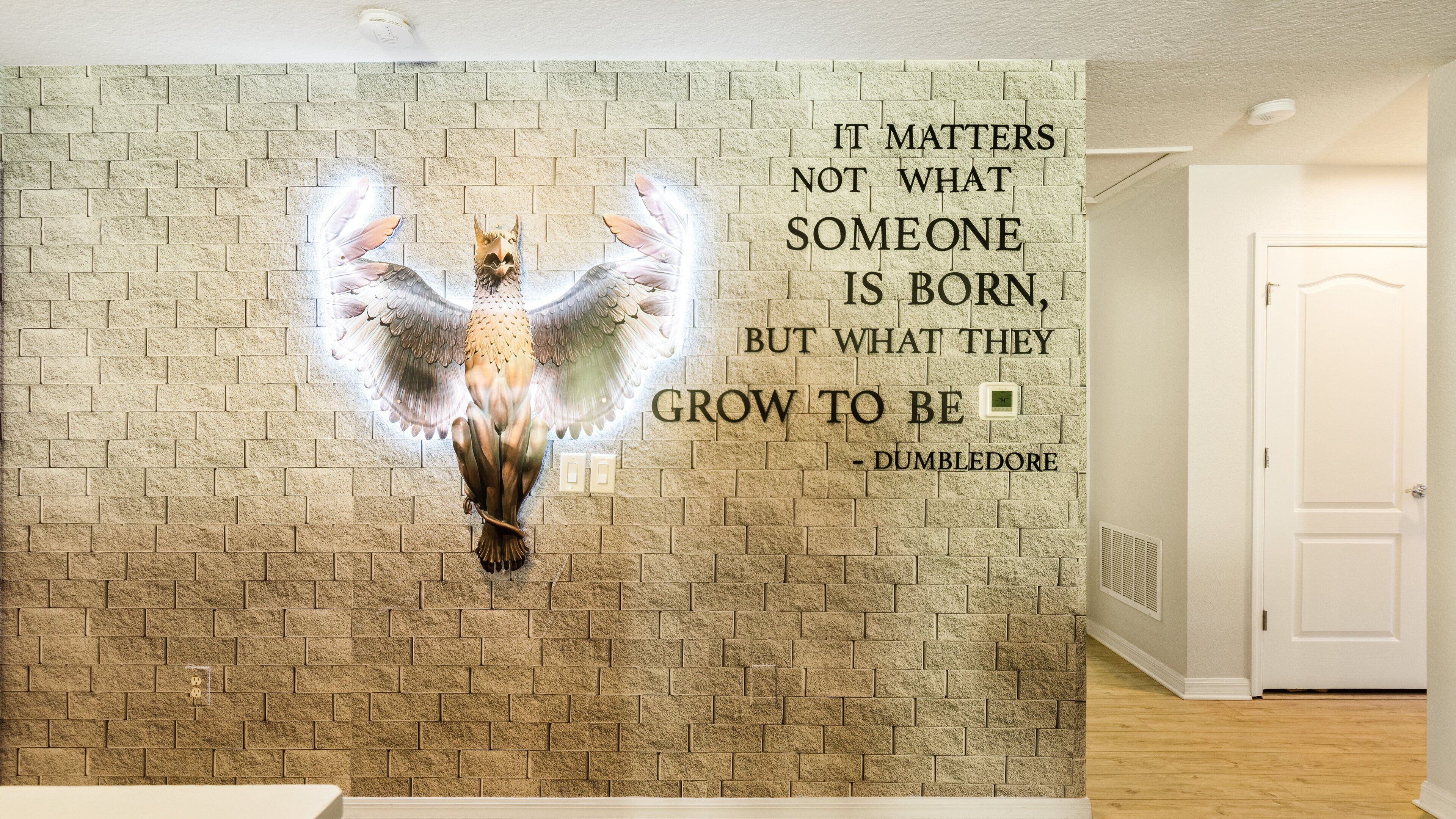 A wall with a quote and an illustration of a bird with wings.
