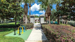 A pathway leading to a gated entrance with a clear view of a building in the background.