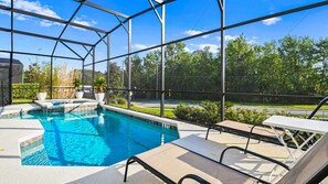 A pool area with clear blue water, surrounded by a glass enclosure, and equipped with lounge chairs. - Spacious 12-bed Villa With Pool & Resort Amenities (Kissimmee)