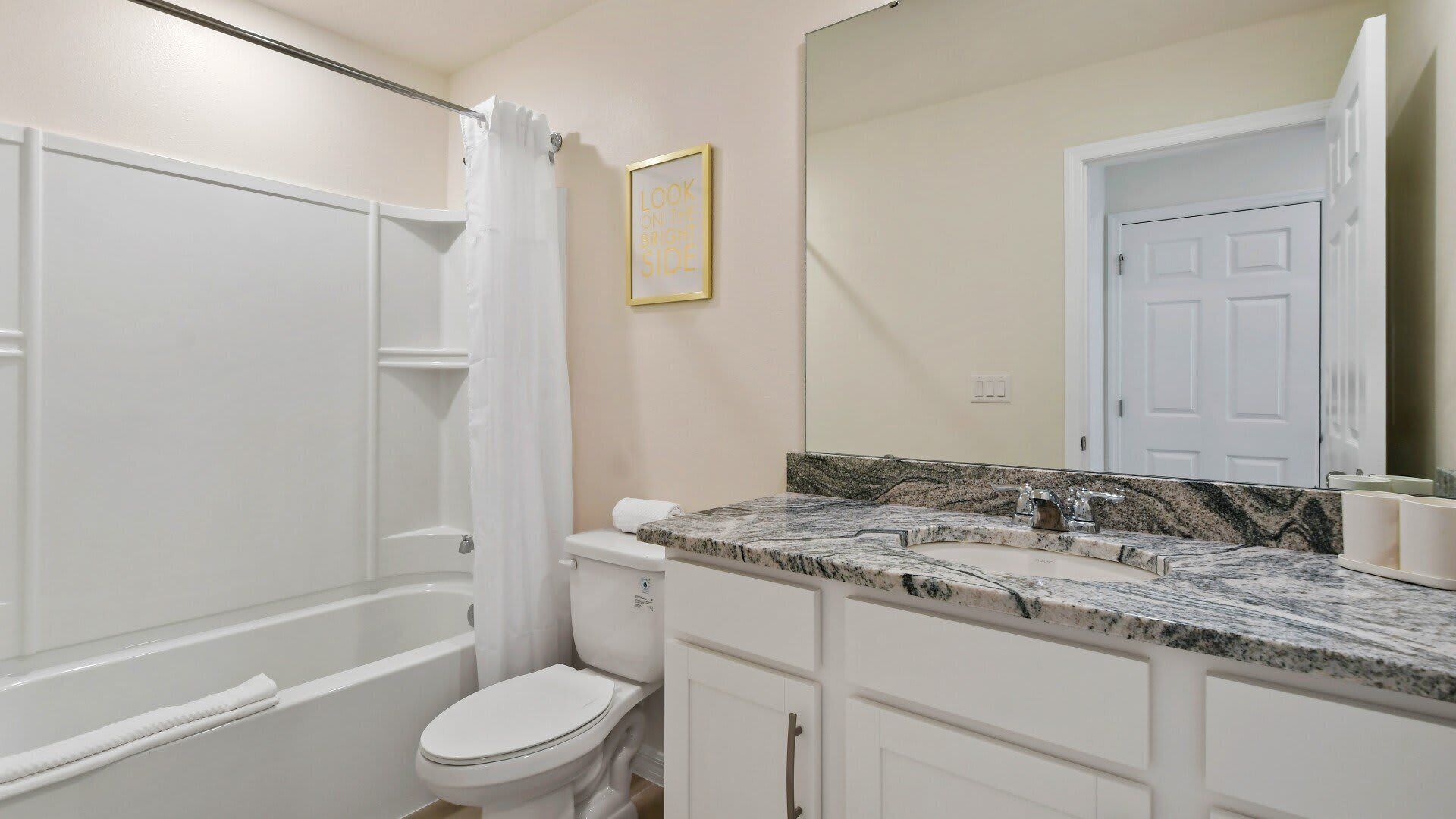 Une salle de bain avec une baignoire, des toilettes et un meuble-lavabo avec un miroir.