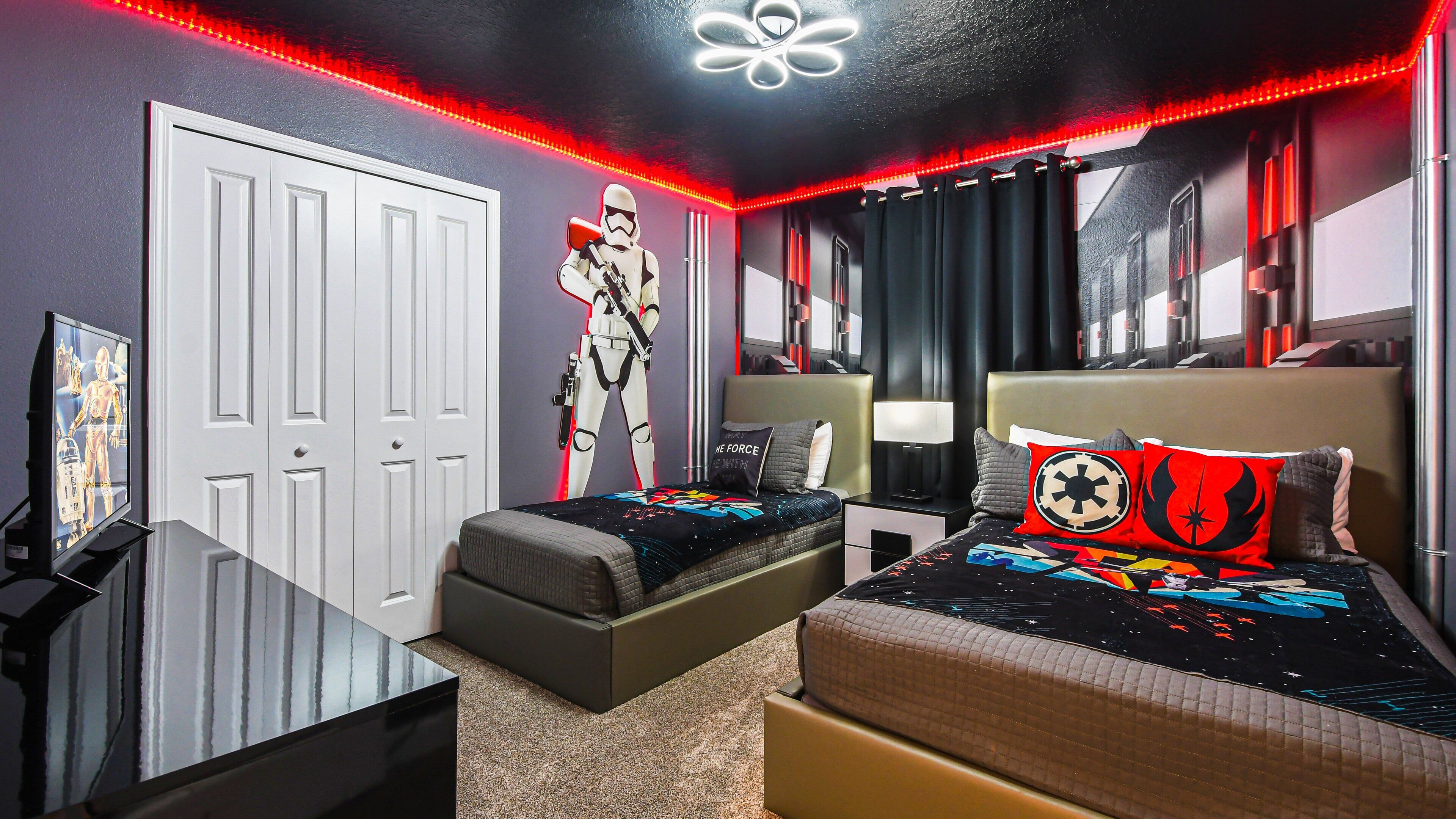 Een slaapkamer met Star Wars thema, inclusief een Stormtrooper beeldje, thematisch beddegoed en een Star Wars poster aan de muur.