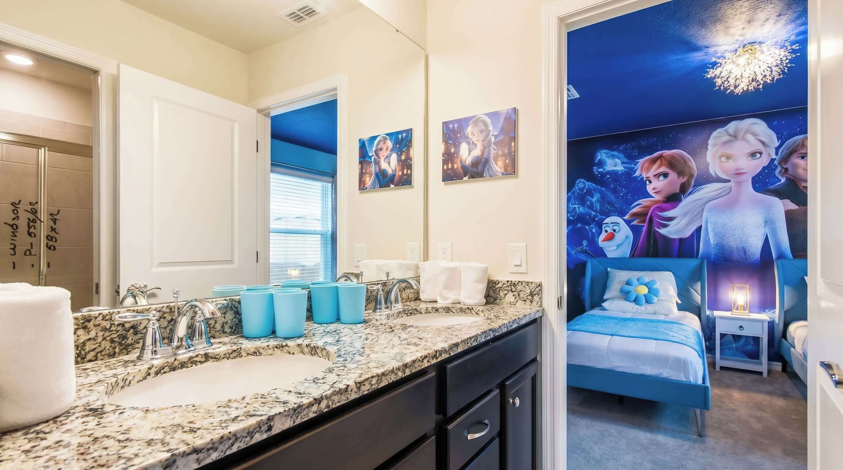 A bathroom with a granite countertop, a sink, and a mirror. There are towels and a blue cup holder on the counter.