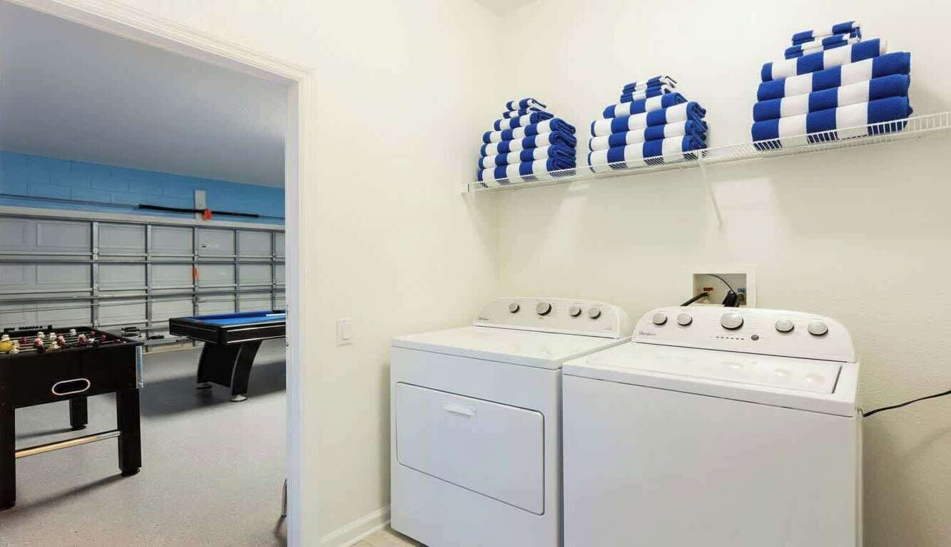 Een wasserette met twee wasmachines en een tafelvoetbaltafel.