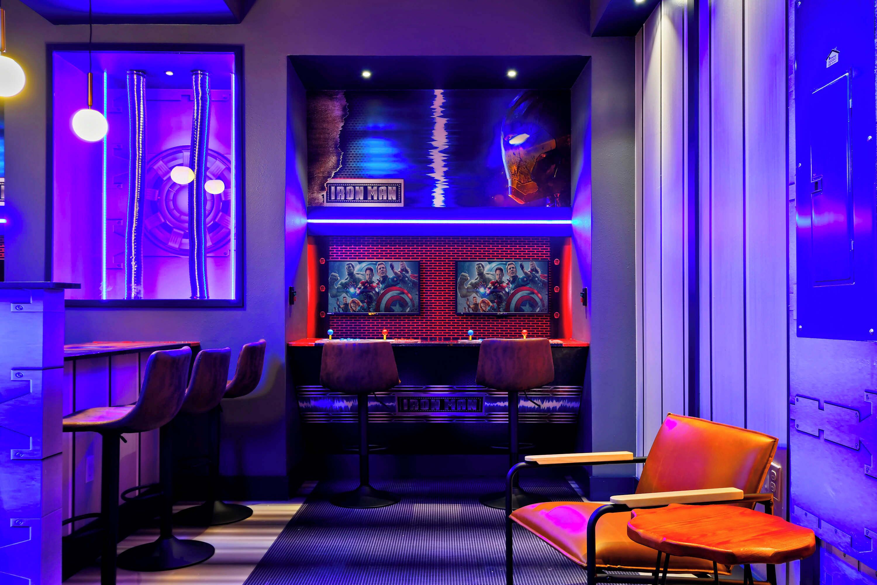 Zona de bar con dos taburetes, una trona y una silla naranja.