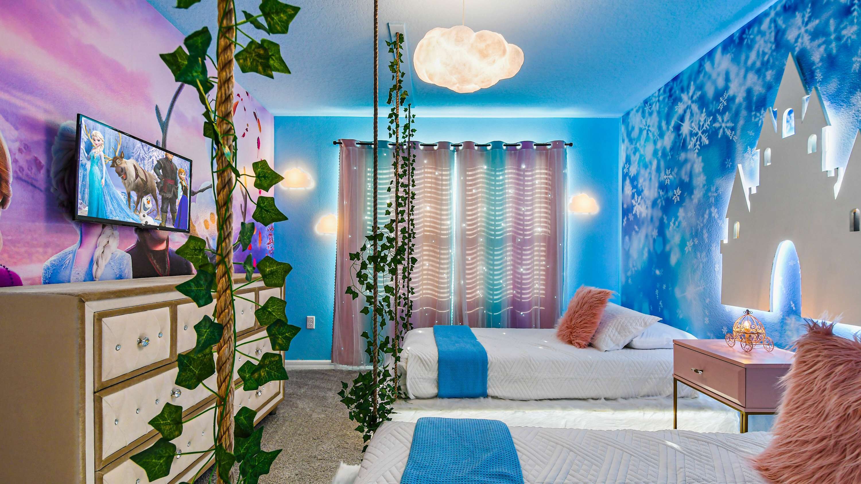 A bedroom with a bed, dresser, and a TV displaying a movie scene.