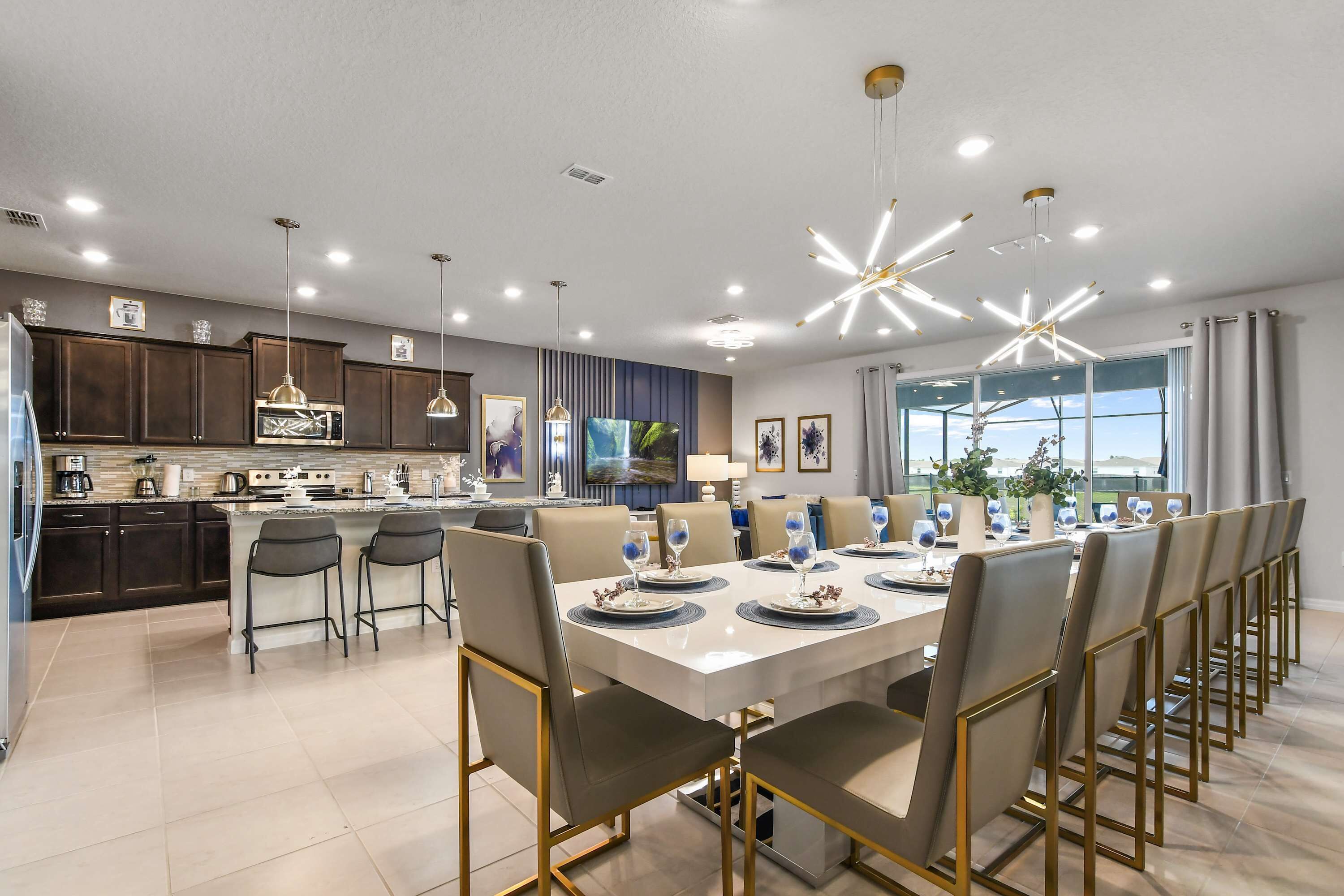 A modern kitchen with dark cabinets, a central island, and a dining area with a white table set for six.