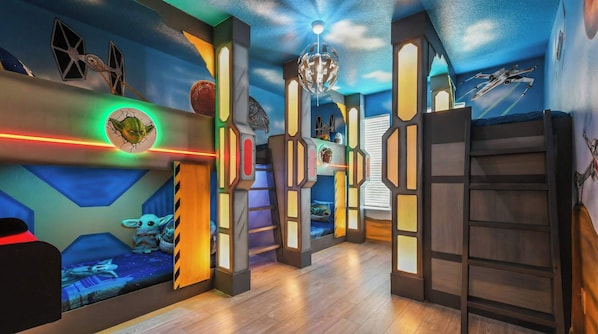 A room with a Star Wars theme, including wall art and a Star Wars character.