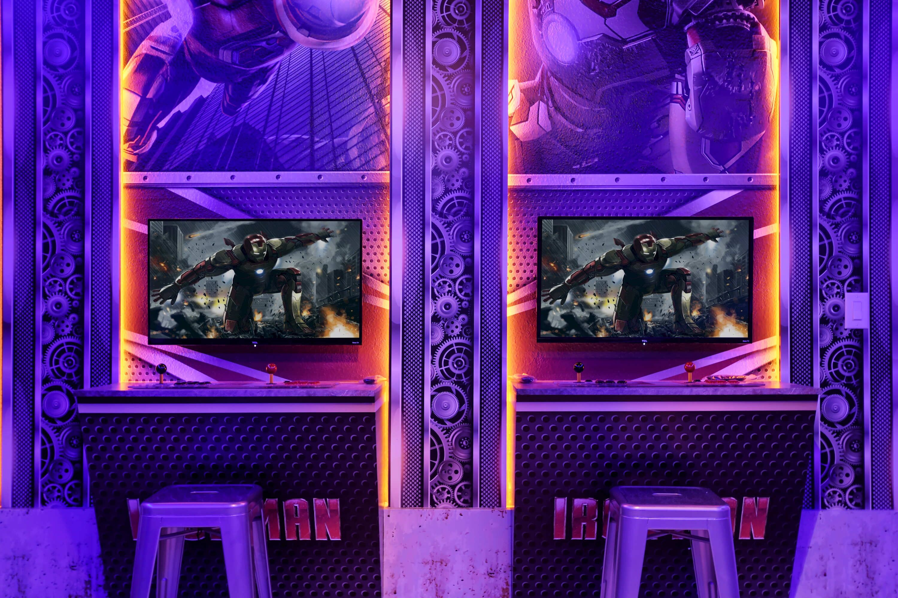 Un espace de jeu équipé de deux écrans affichant un jeu vidéo, le tout agrémenté d’une décoration métallique et mécanique.