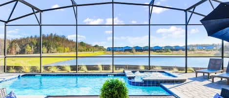 A pool area with a view of a lake and buildings in the background.