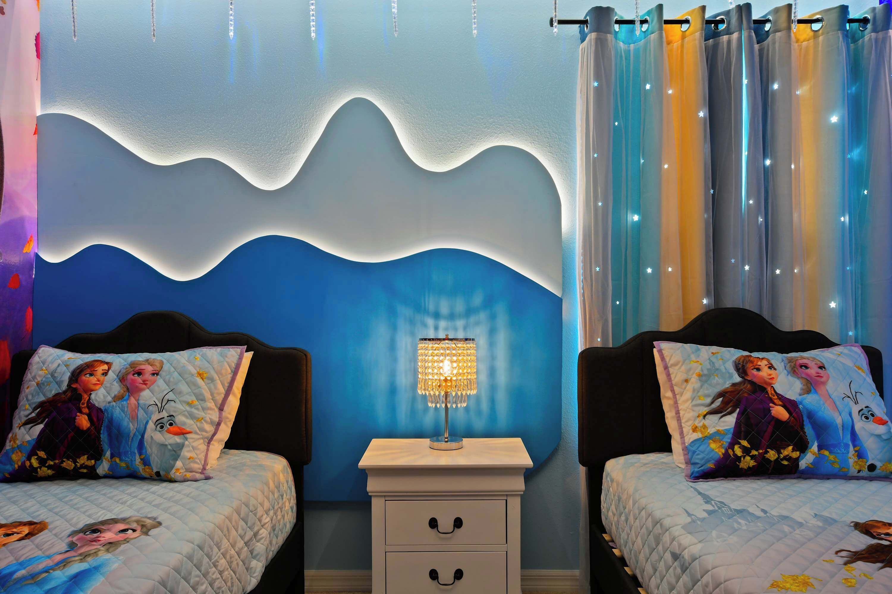 A bedroom with two beds, a nightstand, and a wall with a wave design.