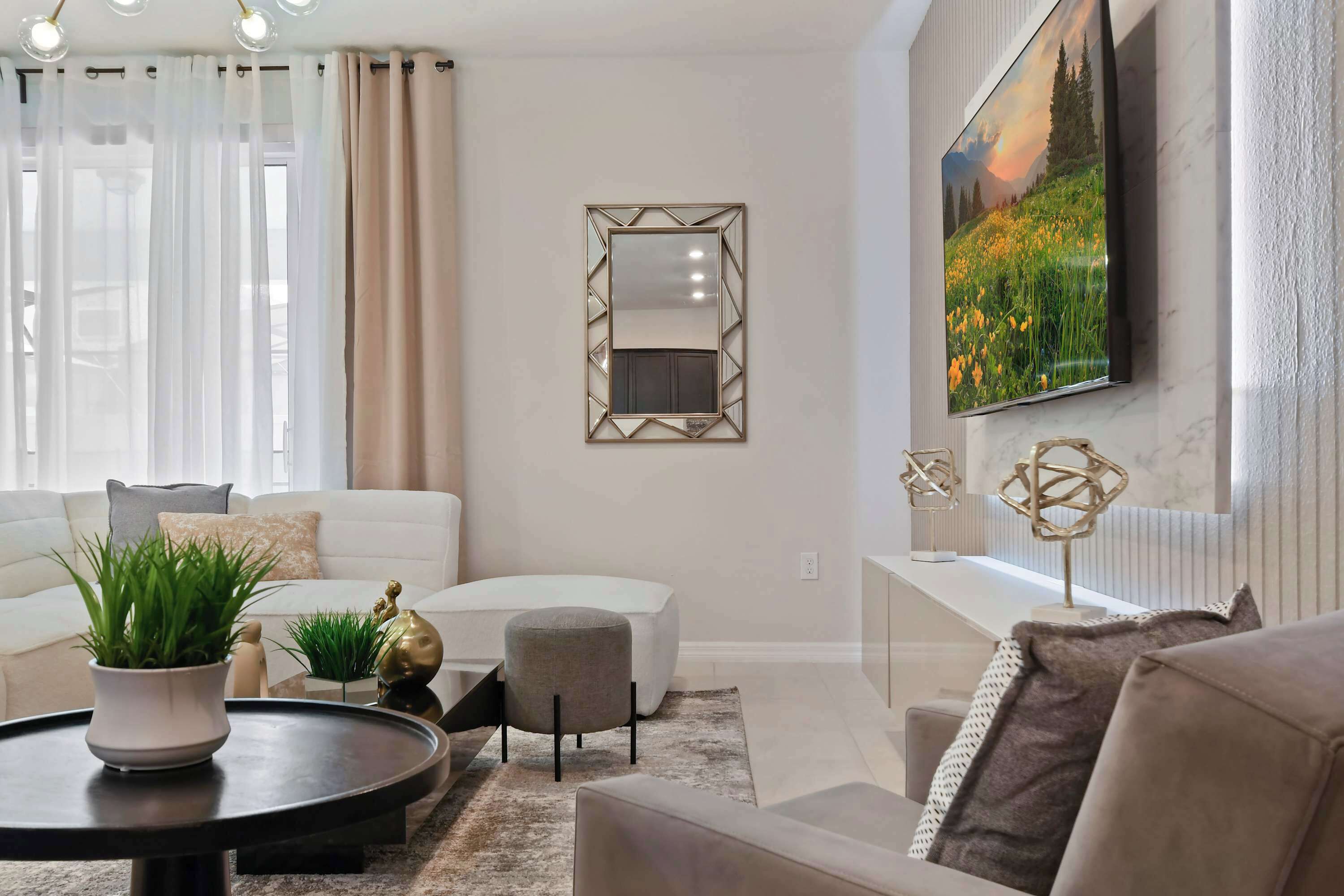 Una sala moderna con sofá, reposapiés, una mesa de centro y elementos decorativos.
