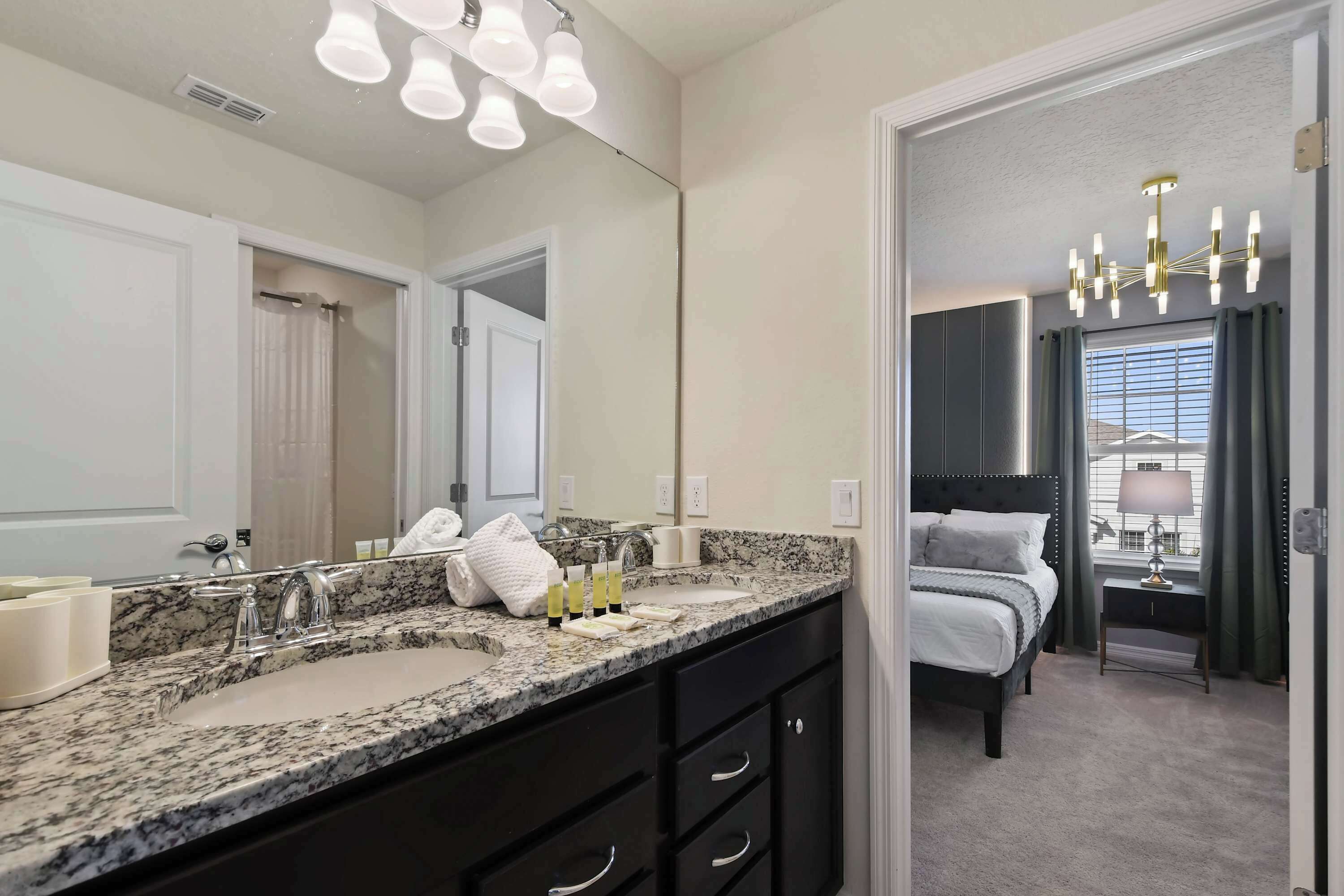 A modern bathroom with dual sinks, a large mirror, and a vanity with drawers.