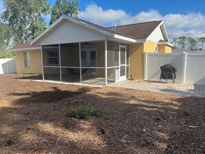 A house with a covered patio, a fenced backyard, and a barbecue grill. - FALL SPECIAL 15% off through December!  FULLY FURNISHED,COZY COTTAGE (North Port)
