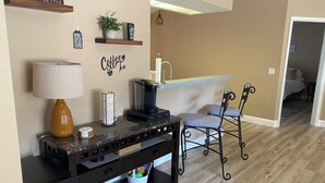 Uma cozinha com espaço para café, lava-louças e área de jantar com duas cadeiras.