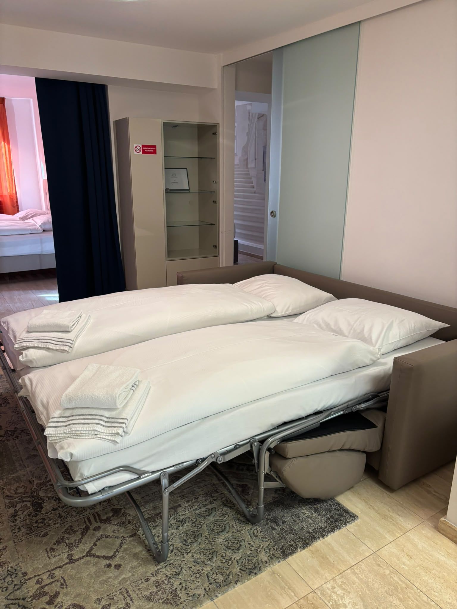 Habitación de hotel con dos camas, un armario y baño.