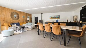 Una sala moderna con sofá, mesa de centro y comedor con sillas.