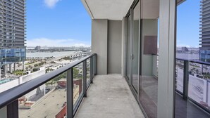 A balcony with a view of a cityscape, including a bridge and water body.