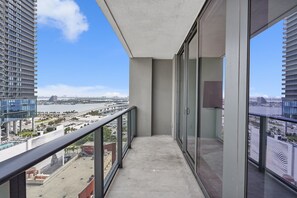 A balcony with a view of a cityscape, including a bridge and water body.