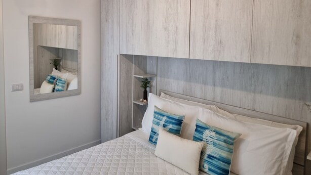 Ein Schlafzimmer mit Bett, Spiegel und Kleiderschrank.