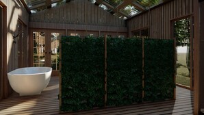 Uma área de spa moderna com uma grande banheira de banho branca, painéis de madeira e um jardim vertical verde.