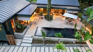 A modern house with a swimming pool, outdoor seating, and a well-maintained garden.
