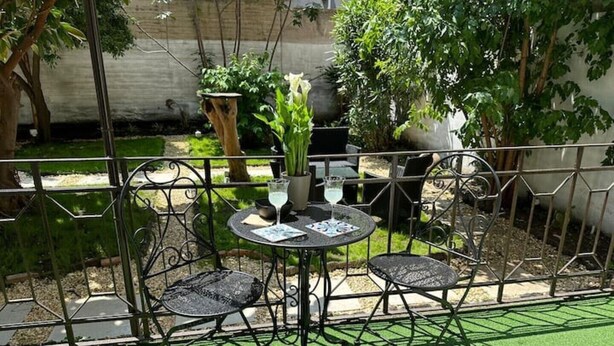 A patio with a round table and four chairs, surrounded by a metal fence. - Executive suite (Catania)