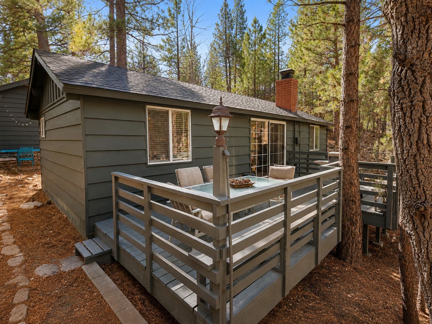 A cabin with a deck, a table, and chairs.