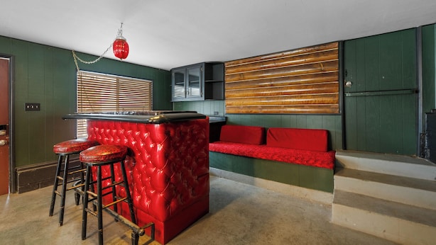A bar area with a red bar stool, a red cushioned bench, and a wooden slatted wall. - Boulder Bay Lakefront Getaway (Big Bear Lake)