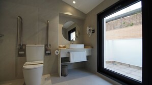 Uma casa de banho moderna com sanita, lavatório e espelho.