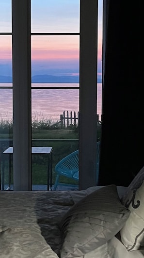 Enjoy a serene view of the water and distant mountains from this room's large window.