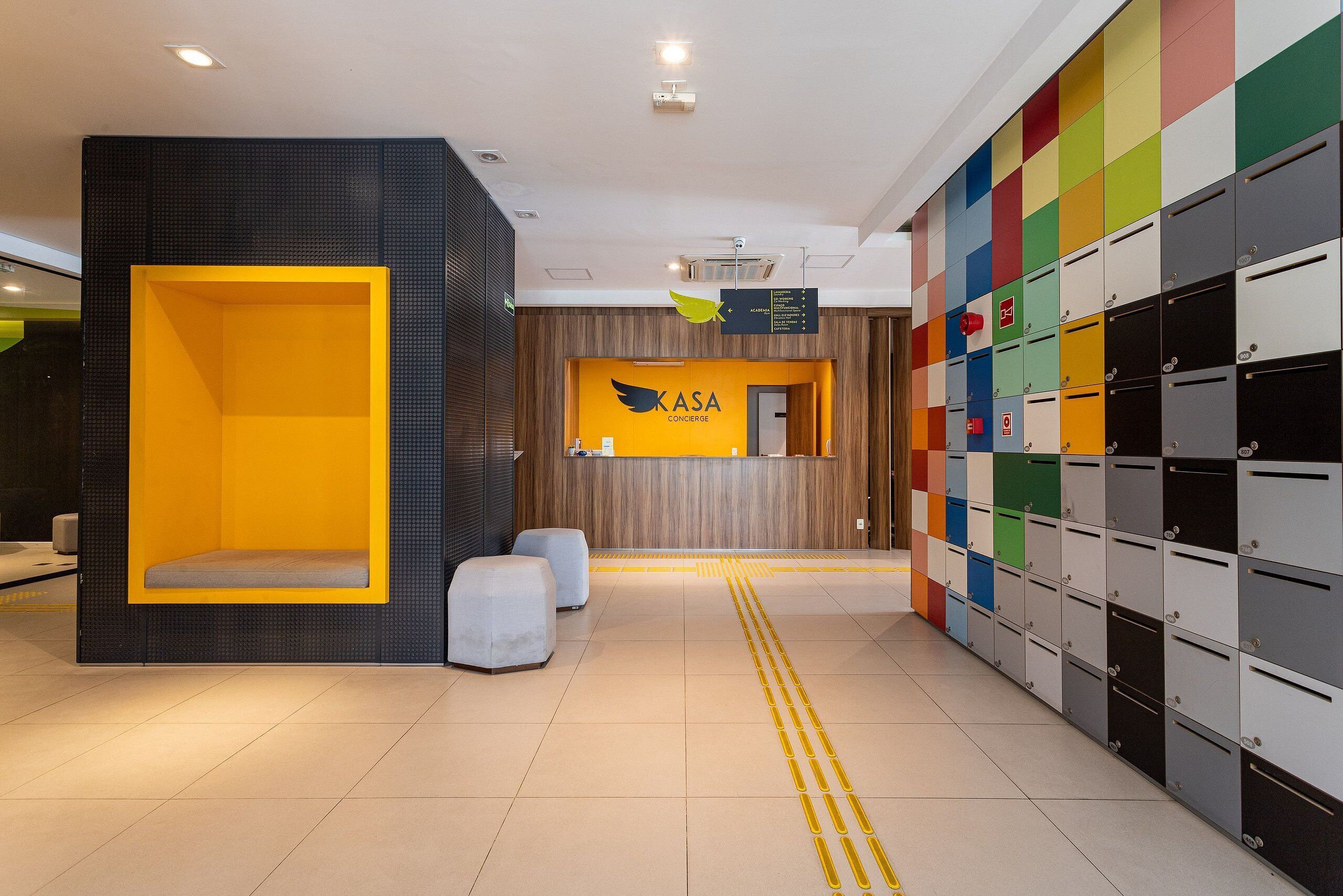 A hotel lobby with a reception desk, storage lockers, and seating areas.