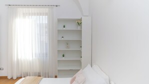 A bedroom with a bed, a white wardrobe, and a window with sheer curtains. - La Casa di Sasà - Maiori - Amalfi Coast - Elegant Accomodation (Maiori)