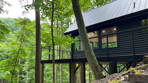 A modern wooden cabin with a balcony, surrounded by a forest. - NEW The Outlook (Laurelville)