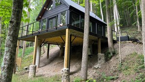 A modern wooden cabin with a balcony, surrounded by trees. - NEW The Outlook (Laurelville)