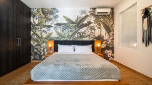 A bedroom with a large bed, dark wooden wardrobe, and a tropical mural on the wall. - Peaceful Retreat-2BR,Canggu (Mengwi)