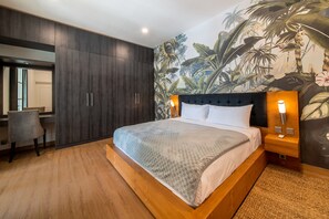 Ein modernes Schlafzimmer mit einem großen Bett, einem Schreibtisch und einer Wandmalerei von tropischen Pflanzen.