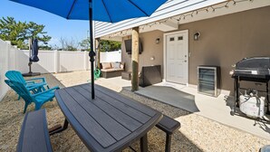 An outdoor patio with a table and chairs, a barbecue grill, and a covered seating area. - Newly Built Luxury Townhouse in Ortley Beach! (Seaside Heights)