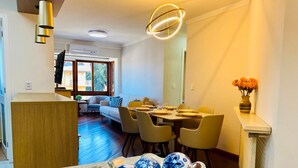 A dining area with a table set for four, a sofa, and a decorative bowl with blue and white ceramic eggs.