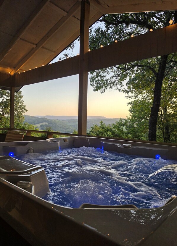 A hot tub with a view of a mountainous landscape.